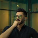 man in black button up shirt wearing black framed eyeglasses